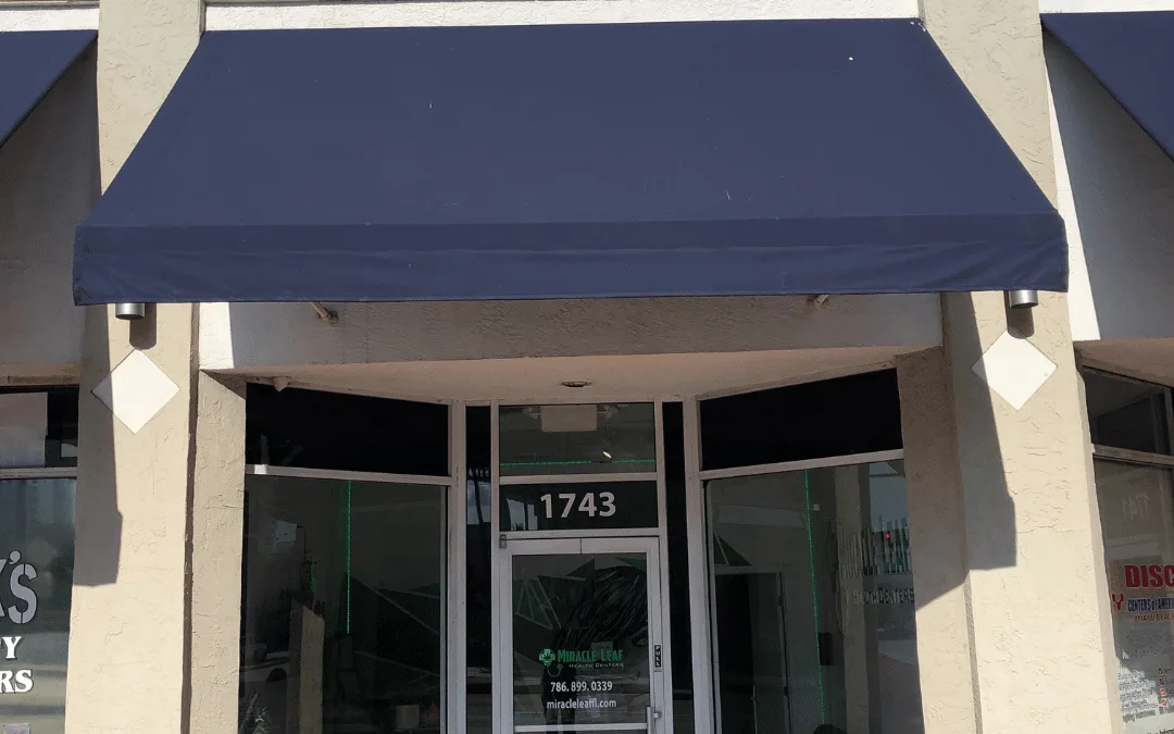The Miracle Leaf® Health Centers clinic at 1743 Alton Road, South Beach: a glass door numbered 1743 under a navy awning, in a row of shopfronts, with the clinic name and phone number on the glass.